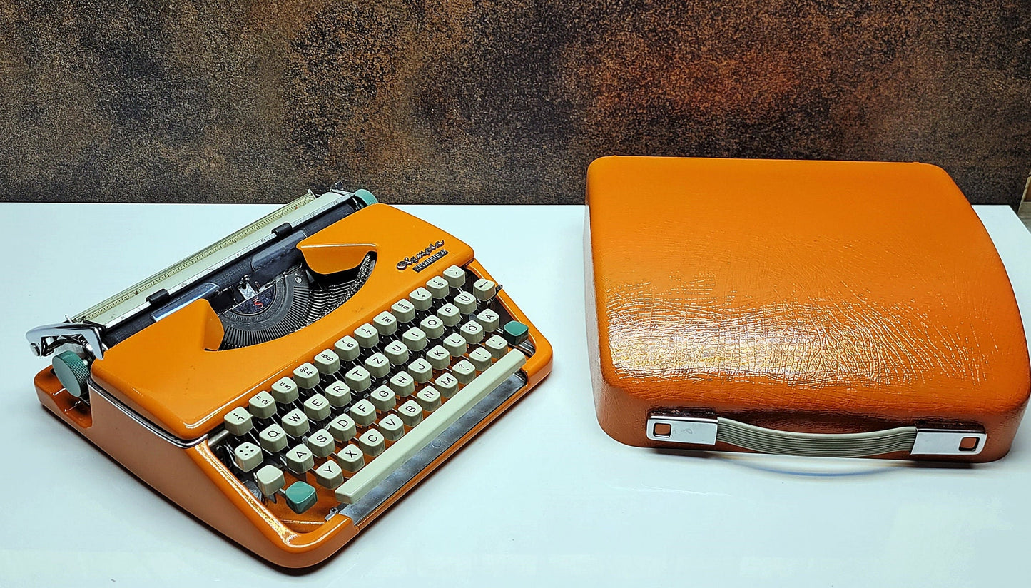 retro writing with the Olympia Splendid 33/66 typewriter orange - a fully refurbished vintage writing machine with a matching carrying case.