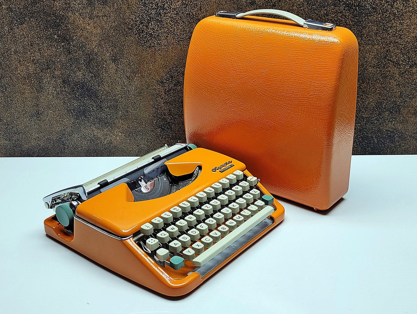 retro writing with the Olympia Splendid 33/66 typewriter orange - a fully refurbished vintage writing machine with a matching carrying case.